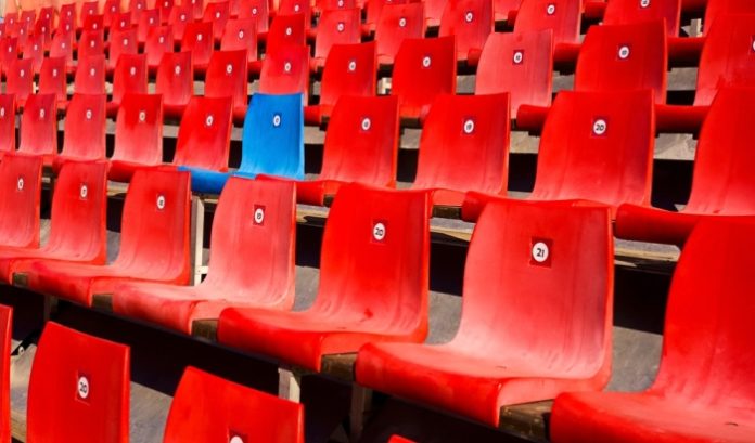 A blue seat stands out among red ones - standing out from the crowd like Jackpocket is doing with its sweepstake product