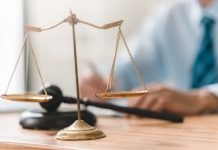 Brightstar Lottery facing legal action over 2024 security breach Scales of justice on a lawyer's desk, concept of legal challenge