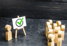 Quartet of Brazil lotteries set up industry interest group Wooden figures facing another wooden figure next to a whiteboard, concept of lobbying
