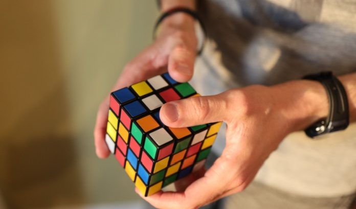 Rubik's hand holding a Rubik's cube