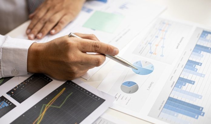A man looking over graphs and charts, symbolic of a Chief Financial Officer like Pollard's who has just stepped down