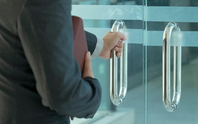 A businessman leaving a building, symbolising the Deputy CEO's departure from Veikkaus