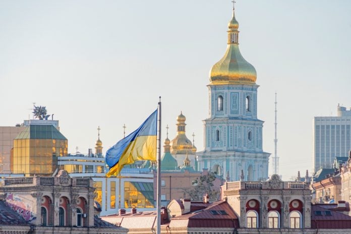 Skyline of Kyiv, Ukraine, with Ukrainian flag in foreground